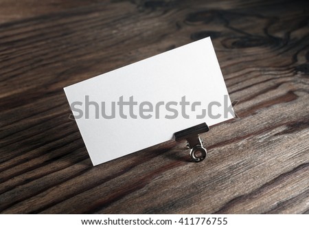 Blank white business card on dark brown wooden background. Mockup for branding identity. Blank template for graphic designers portfolios.
