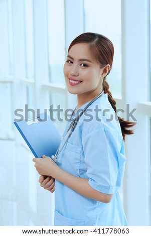 Cheerful young Vietnamese doctor with documents