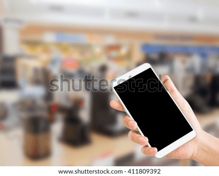 woman use mobile phone and blurred image of coffee making machine zone in the department store