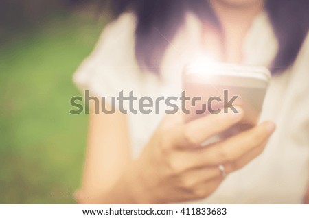 Blur woman using smart phone in park abstract background. Retro color style.