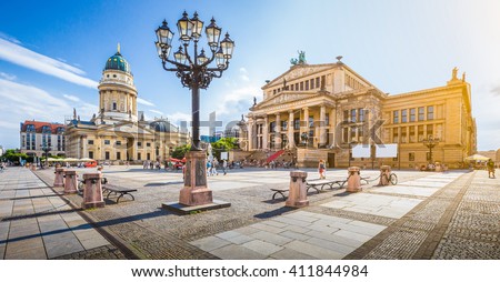 Panoramic view of famous Gendarmenmarkt square with Berlin Concert Hall and German Cathedral in golden evening light at sunset with blue sky and clouds in summer, Berlin Mitte district, Germany Royalty-Free Stock Photo #411844984