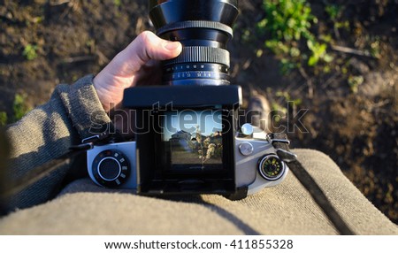 man photographer is making landscape photography with old film camera in spring or summer, tourism and hiking concept. top view. copy space