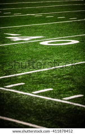 Picture of football field 40 yard line number marker. Photo is vertical, high resolution, has a shallow depth of field, and has copy space for adding text.