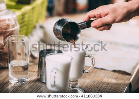 barista making latte , hands and cups in the picture