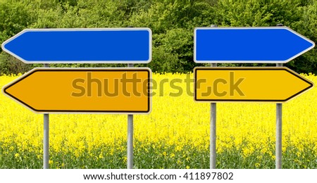 Blank yellow and blue road pointers on yellow canola field background,  text place. Sign posts, different directions