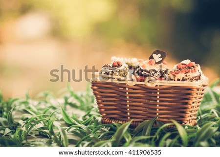 Close up small cake in basket with bokeh nature background. Vintage or retro tone.