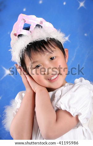 The little asian girl looks like an angel in blue stars background.