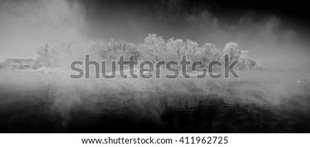 Winter sunrise over the river with fog. trees under the snow. mystical picture. selective focus