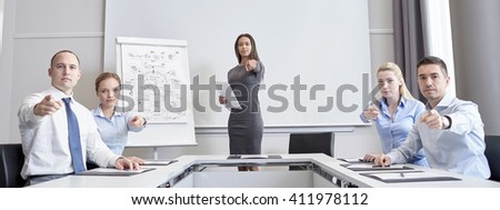 business, people and teamwork concept - group of businesspeople meeting and pointing finger at you in office