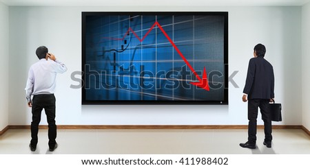 Businessman standing looking at the TV screen