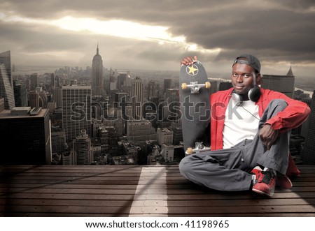 black guy with skateboard with top view of New York on the background