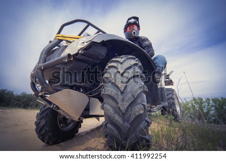 The race in difficult conditions on the sand on a quad bike. Royalty-Free Stock Photo #411992254