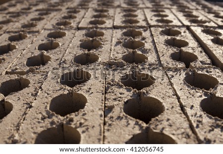Rows of vertical bricks. Each brick has three holes through it. 