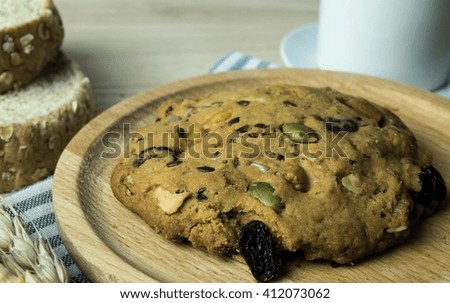 Oat cookies (Almond,currant,sunflower seed) on wooden dish with Wheat Bread and coffee on wooden table 