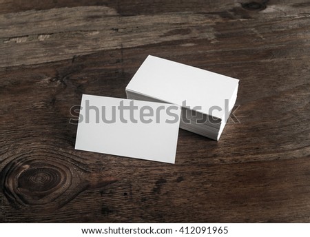 Blank white business cards on dark wooden background. Mockup for branding identity for designers.