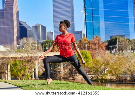 Runner girl stretching listening music earphones in the city park