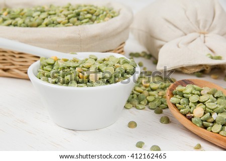Photo of bowls full of lentil seeds on white wooden surface