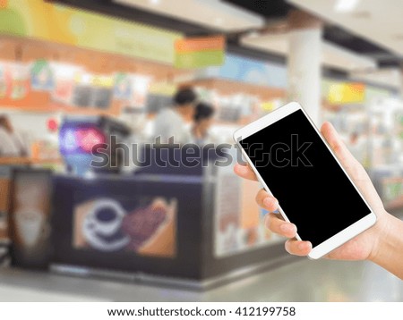 woman use mobile phone and blurred image of coffee shop in food court
