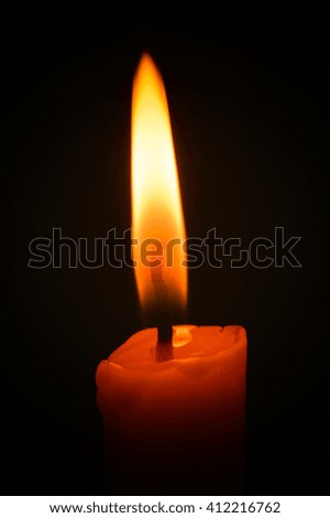 Candle flame closeup isolated on black.