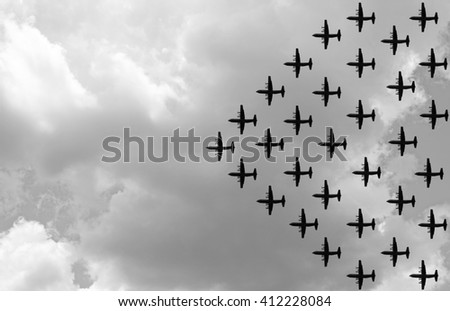Silhouette of a propeller military airplane in an attack formation against a gloomy cloudy sky. Processed in monochrome. Royalty-Free Stock Photo #412228084
