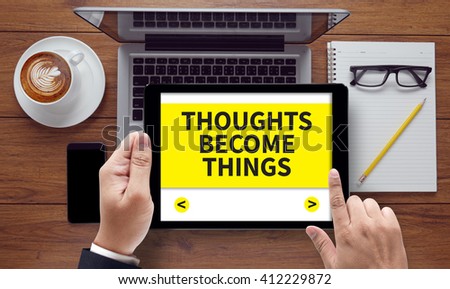 THOUGHTS BECOME THINGS, on the tablet pc screen held by businessman hands - online, top view