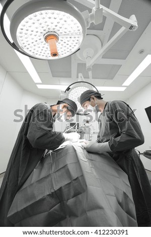 two veterinarian surgeons in operating room take with selective color technique and art lighting