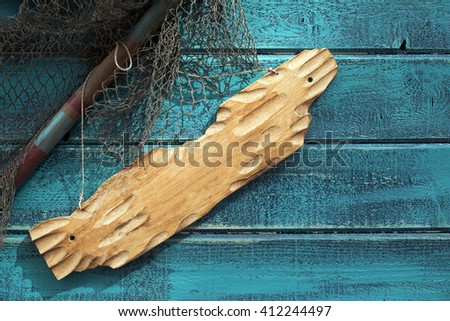 Piece of wood hanging on the wall with snare net for fishing, sea scene