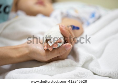 Mother holding a baby hand in hospital. Royalty-Free Stock Photo #412245628