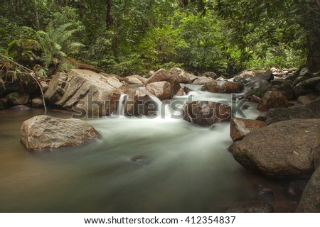 Mountain waterfall river. The picture have a soft focus or blurry image due to the slow shutter speed to obtain the silky water flow affect
