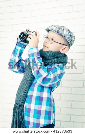 Little boy in a cap photographs, closeup