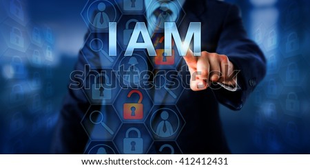 Security manager is pushing IAM on a touch screen interface. Information technology security concept for Identity and Access Management that is controlling access rights to data resources.