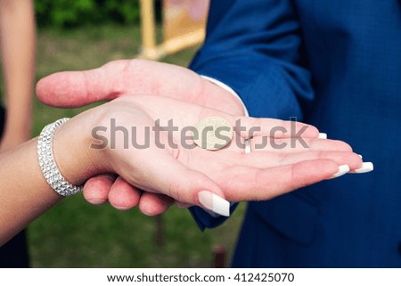 Close up capture of a newlywed hand holding an old happiness coin