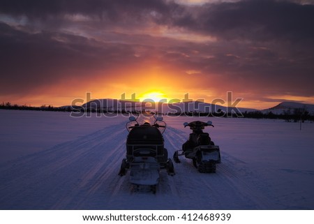 Snowmobiles watching the sunset