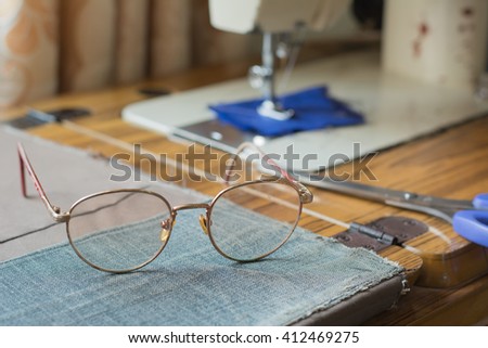 glasses placed in front of a sewing machine.