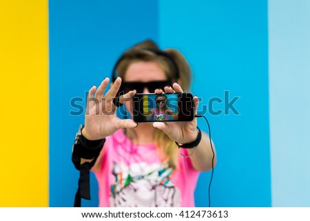 young girl in sunglasses posing in the street and make selfie smartphone camera, crazy woman. hipster 