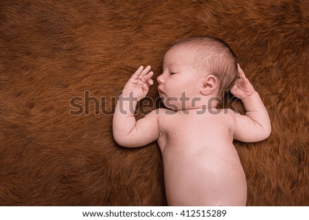 Portrait of a newborn caucasian girl lying on a dark background