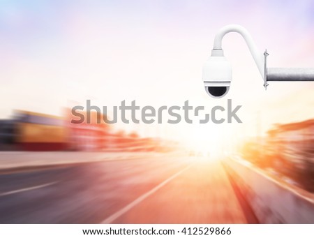 CCTV camera for surveillance driving operating on expressway asphalt road with car in city at sunrise. light sign for car stop and speed reduction. Dangerous,warning signal on a Highway.