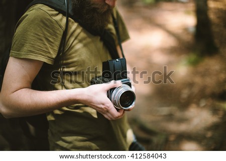 Young man photographing in forest on medium format camera