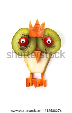 Food art creative concepts. Funny owl with a crown (bird) made of pear, kiwi, sweet tomatoes and carrots isolated on a white background.