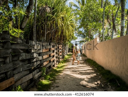 Young couple holding hands on path to Lanikai Beach, Oahu, Hawaii, USA