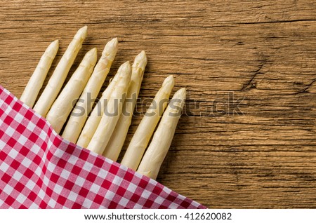 White asparagus on a wooden board with a checkered tablecloth