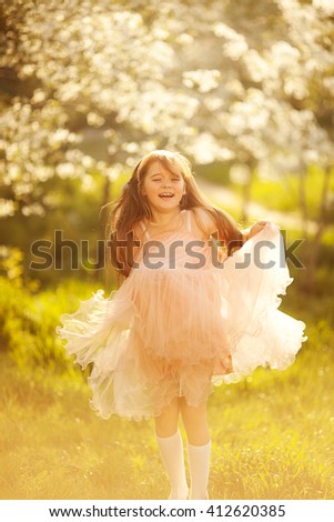little girl dancing in the spring garden