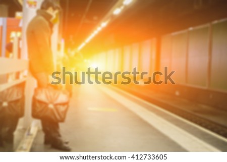 De focused Blur backgroundof  Portrait of a happy young man waiting for train at station with bag in Paris ,Europ abstract background.vintage color