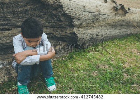 scared and alone, young  Asian child who is at high risk of being bullied, trafficked and abused, selective focus
