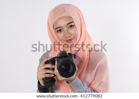 muslim girl photographer holding a dslr camera isolated on a white background.