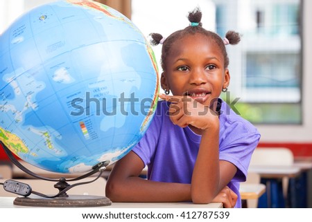 African girl at school with earth globe in background, geography and education concept.