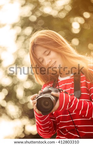 Woman photographing with a dslr camera on sunset.