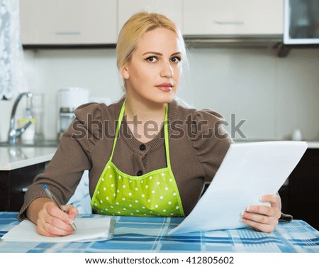 Serious beauty girl reading document at kitchen