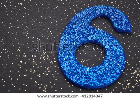 Number six blue color over a black background. Anniversary. Horizontal