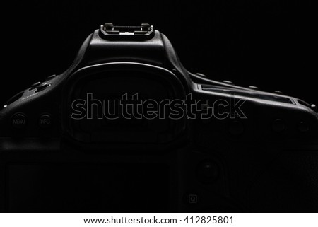 Professional modern DSLR camera low key stock photo/image - Modern DSLR camera with a very wide aperture lens on with highlighted edges against black background